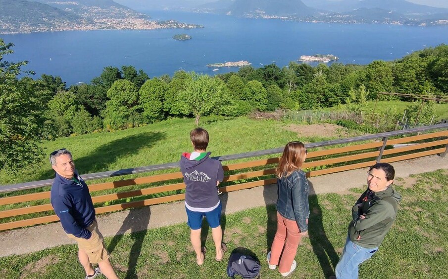 A group of people standing on a grassy hill overlooking a body of water with islands. 5