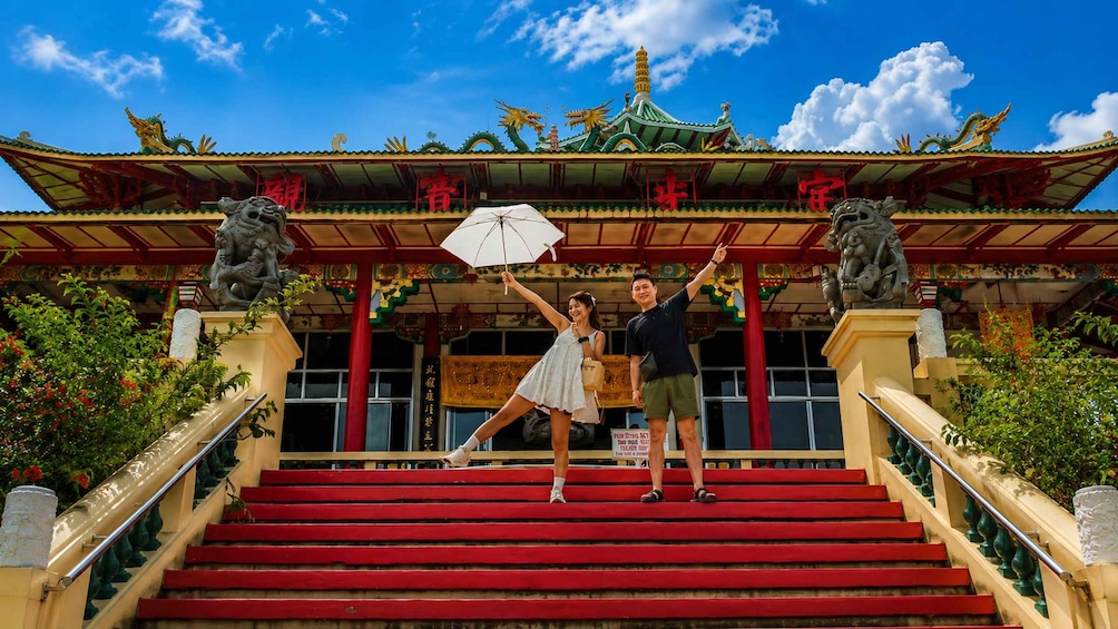 A couple on a staircase with a traditional building in the background. 1