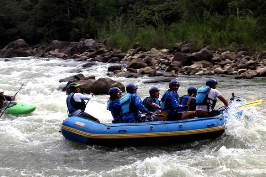 A group of people rafting down a river surrounded by rocks and greenery. 3