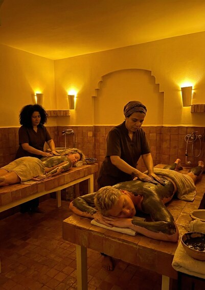 A massage therapy room with three clients receiving treatments. 4