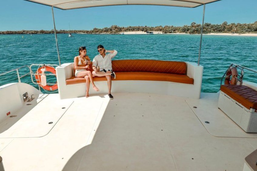 A boat with a white deck, a brown cushioned bench, and a lifebuoy. 5