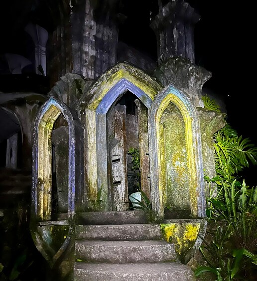 A stone structure with arched doorways and steps leading up to it. 1