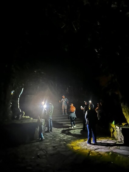 A group of people exploring a cave with artificial lighting. 2