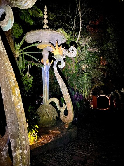 A decorative garden feature with a stone structure, a winding path, and lush greenery. 5
