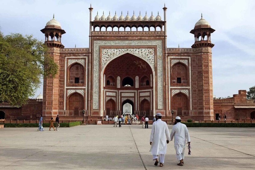 A large, ornate gateway with two towers and a central archway, surrounded by a spacious courtyard. 1
