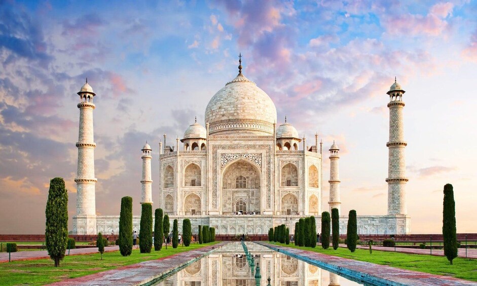 The Taj Mahal with four minarets, a central dome, and a reflection in the water. 2