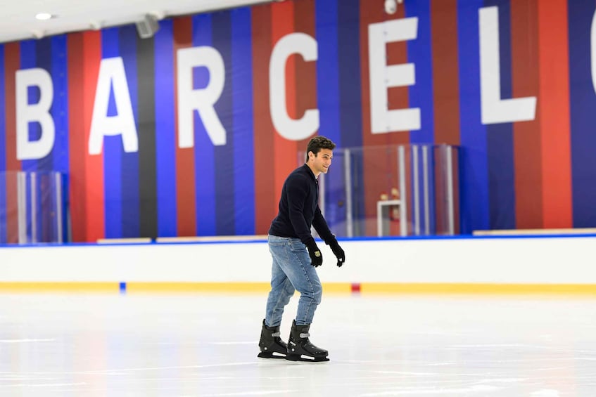 A person ice skating in an indoor rink with a large 'BARCELONA' sign in the background. 4