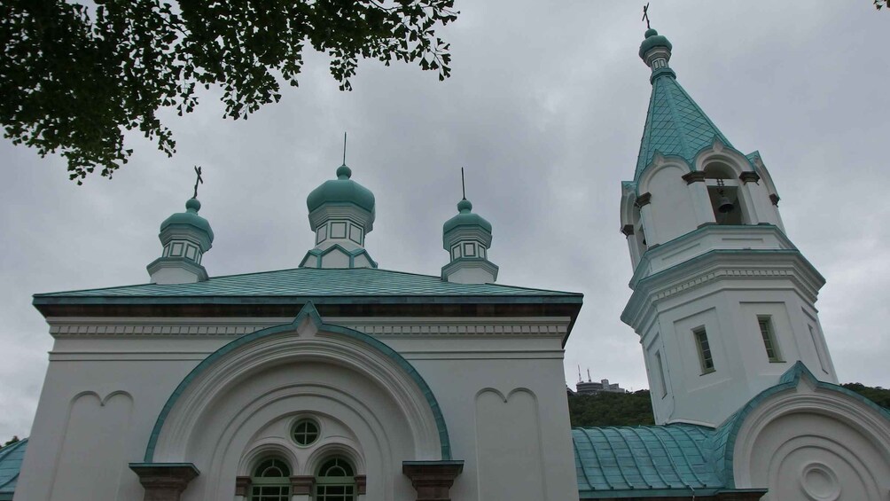A church with three domes and a tall spire. 4
