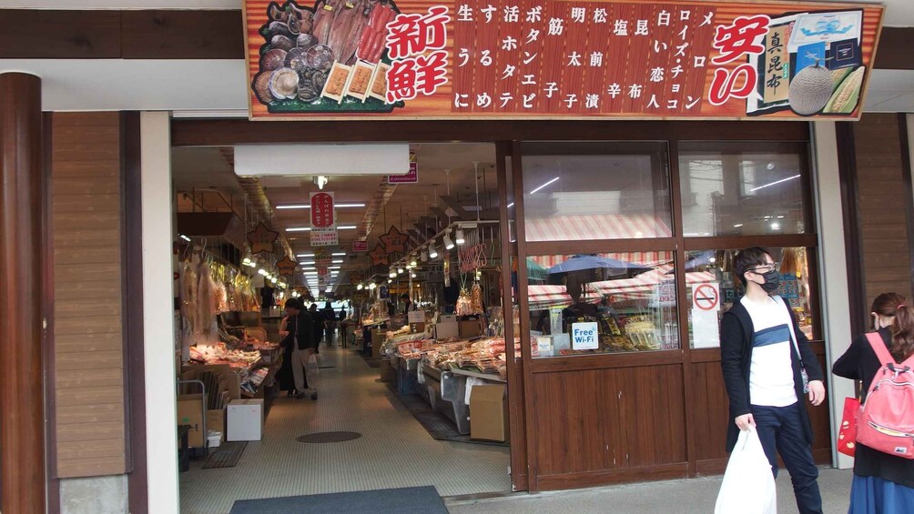 A market with various stalls selling seafood and other goods. 2