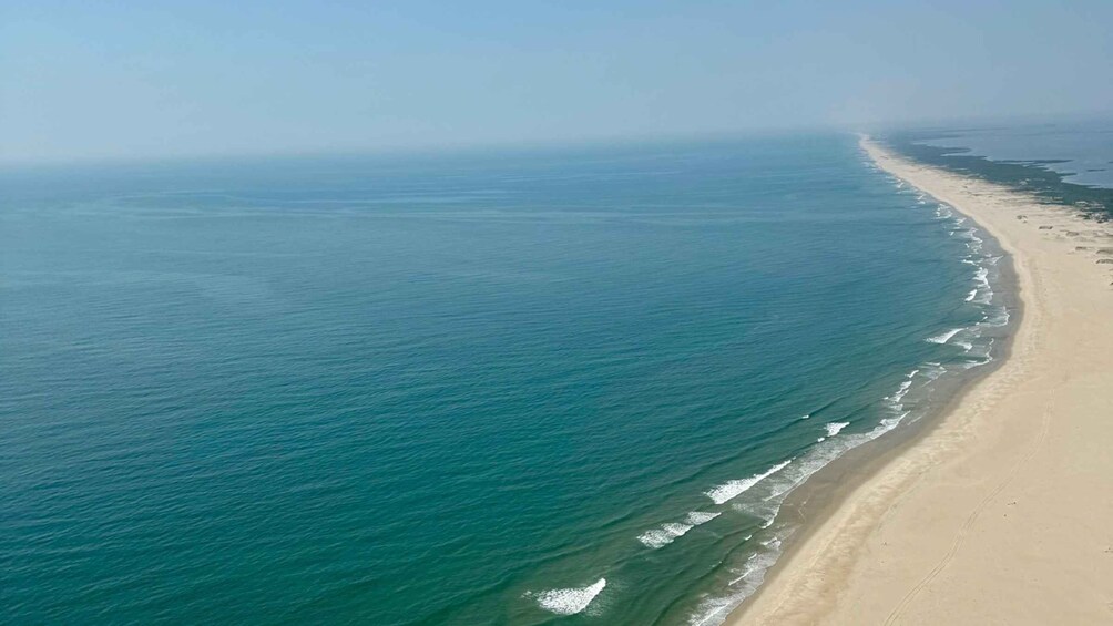 A coastal landscape with a sandy beach and a calm sea. 5