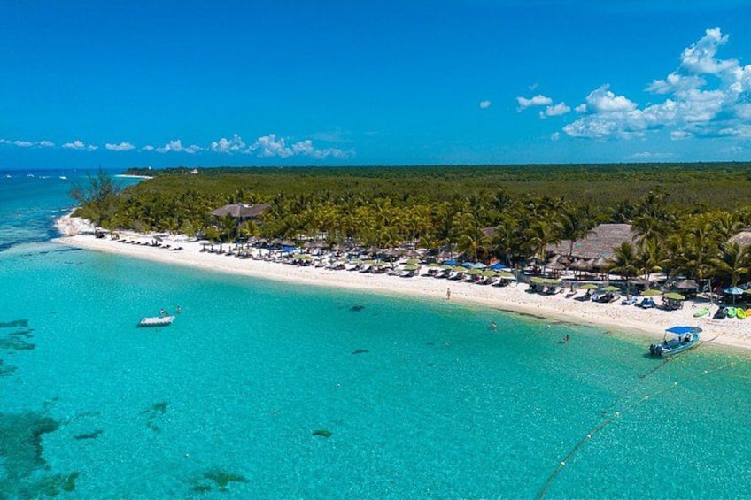 A beach with clear turquoise water, a sandy shore, and a line of palm trees. 2
