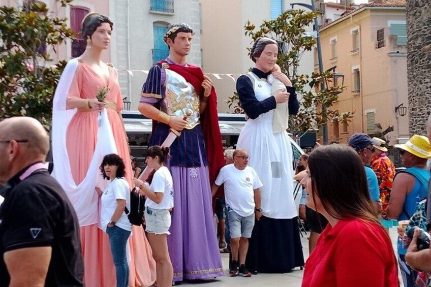 A group of people in historical costumes, a statue, and buildings in the background. 5