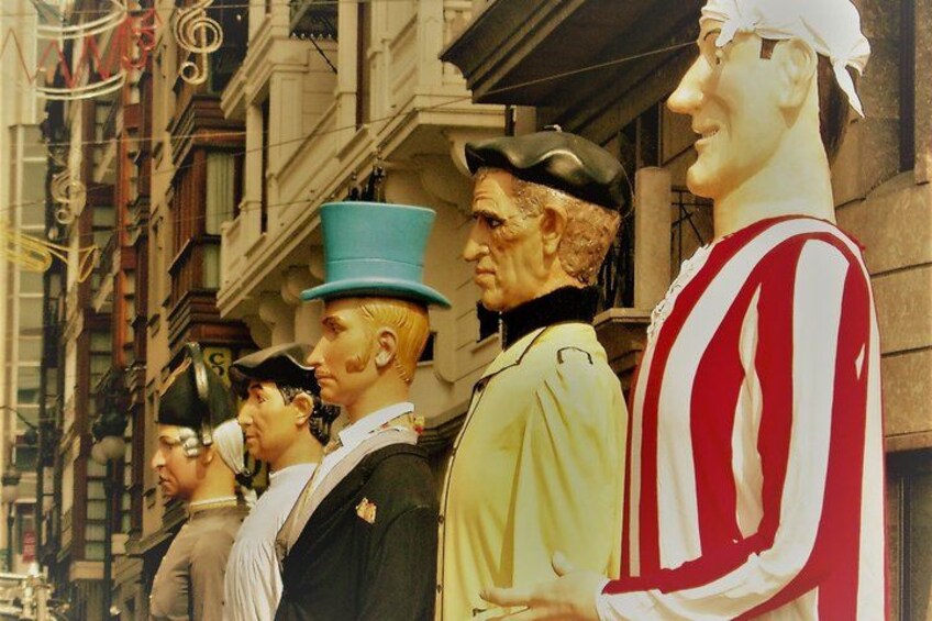 A street scene with a row of statues of historical figures. 2