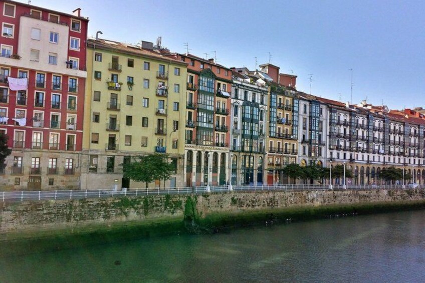A row of colorful buildings along a riverbank. 5