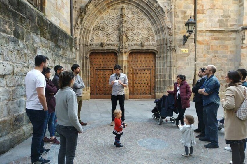 A group of people standing in front of a historic building with ornate doors. 4
