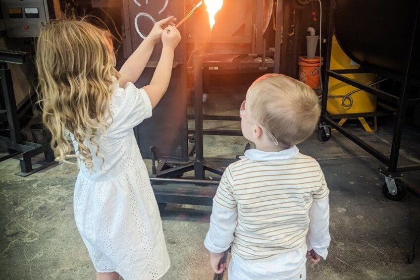 Two children observing a light source through a circular object. 5