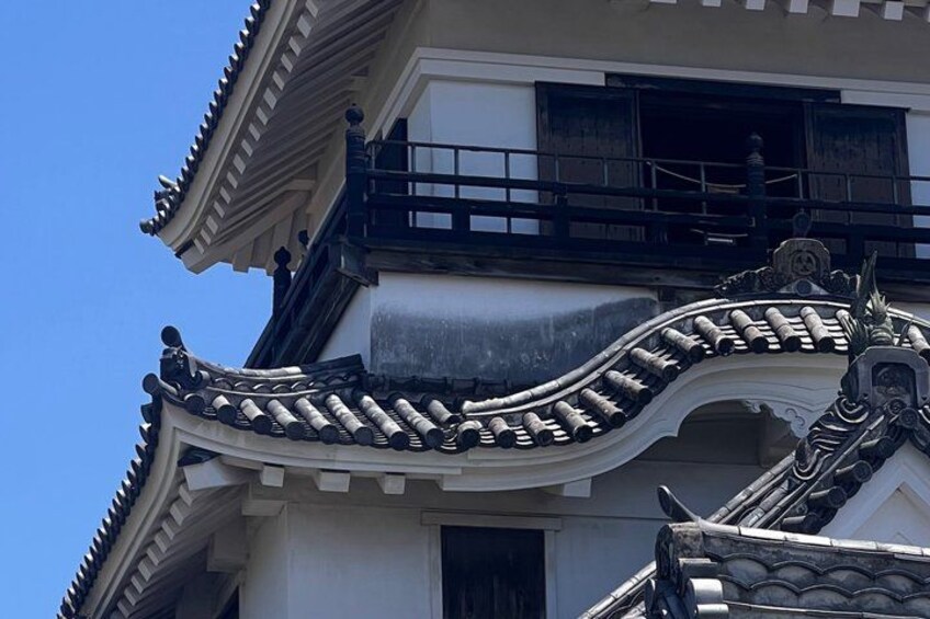 A traditional building with ornate roof tiles and a decorative finial. 1
