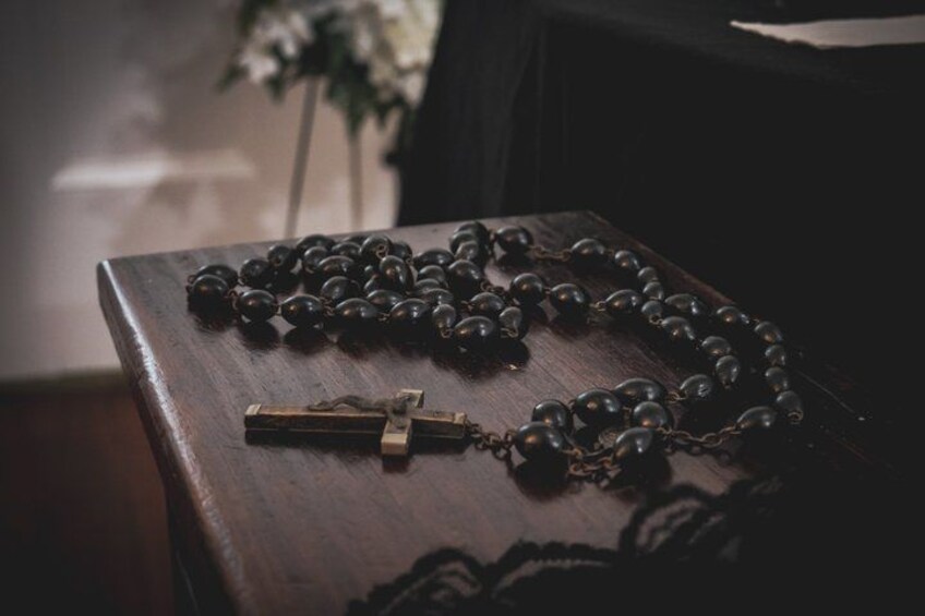 A rosary with a crucifix on a wooden surface. 2