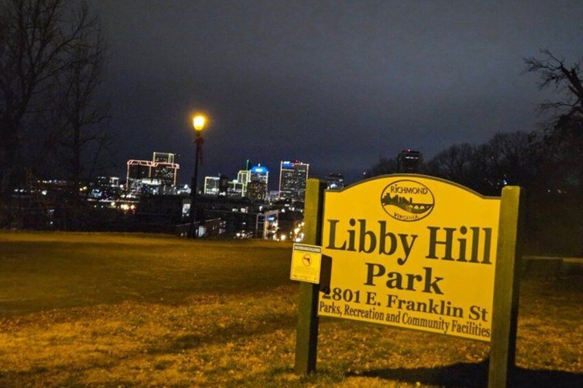 A sign for Libby Hill Park with a city skyline in the background. 5