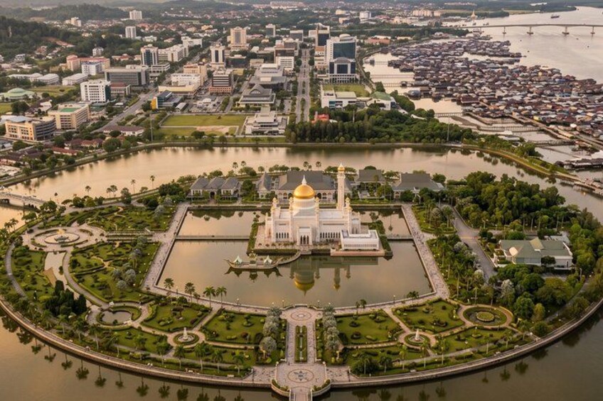 A cityscape with a prominent white building with a golden dome, surrounded by water and greenery. 3