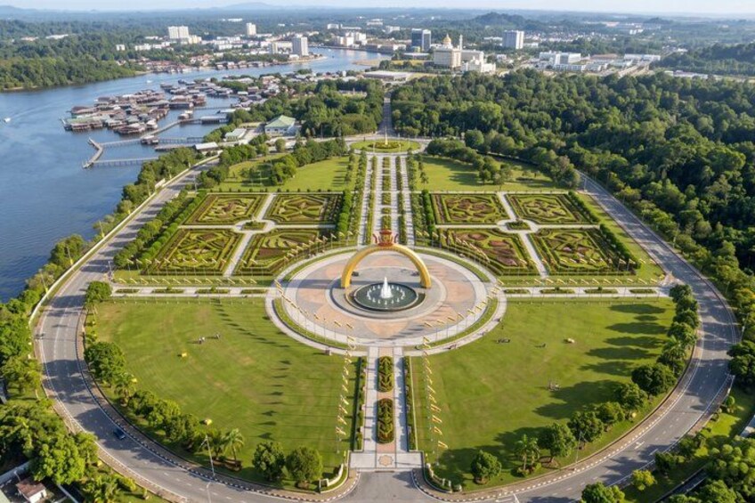 A large circular park with a central fountain, surrounded by well-maintained gardens and a river. 2