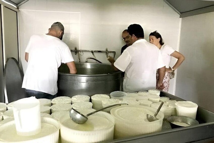 A group of people in a kitchen, some handling large containers, possibly preparing food. 2