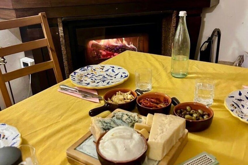 A table with various cheeses, olives, and a bottle of water. 2