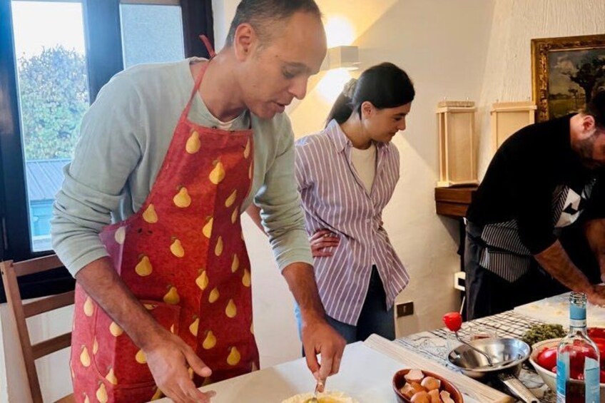 Three people in a kitchen preparing food. 3