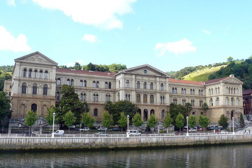 A large classical building with multiple arches and columns, situated by a body of water. 5