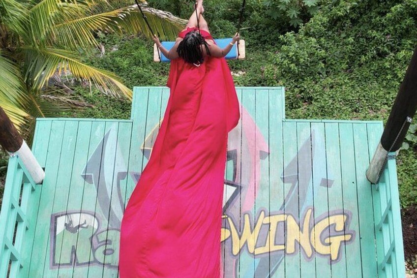 A person in a red dress hanging upside down from a wooden structure with graffiti. 2