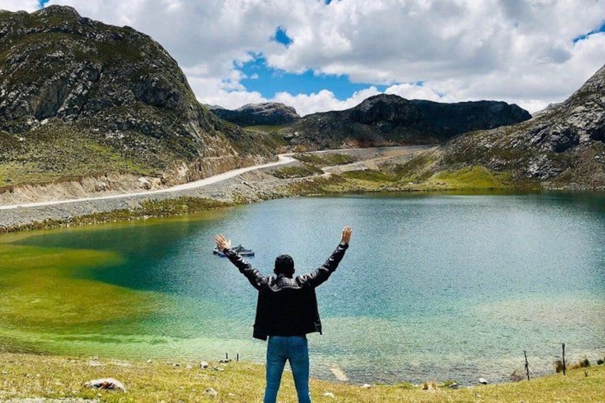 A person standing by a lake with mountains in the background. 4