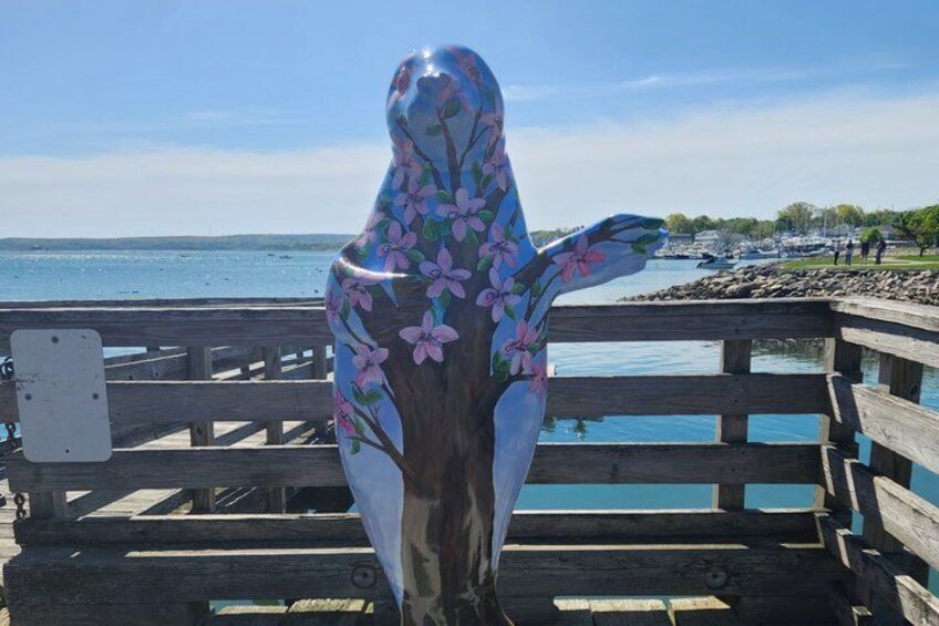 A wooden pier with a sculpture of a bear with floral patterns. 4