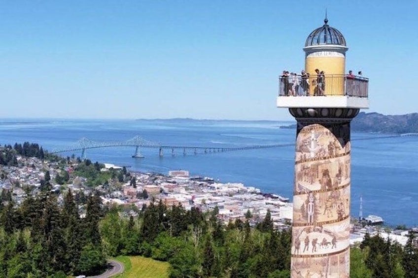 A lighthouse with a yellow top, a bridge in the background, and a coastal town below. 2