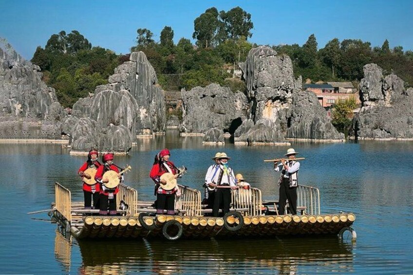 A group of people on a boat playing musical instruments by a rocky lake. 5