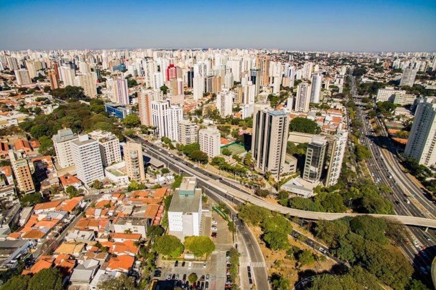 A densely populated urban area with high-rise buildings, roads, and green spaces. 2