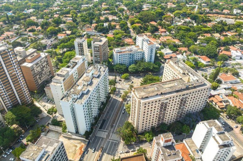An aerial view of a cityscape with high-rise buildings, roads, and green spaces. 3