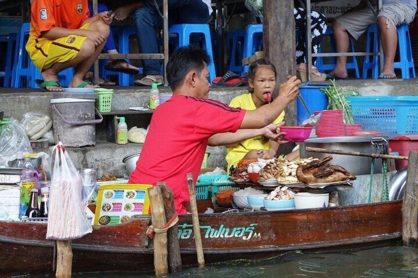 A boat with food items and a person serving food to a child. 4