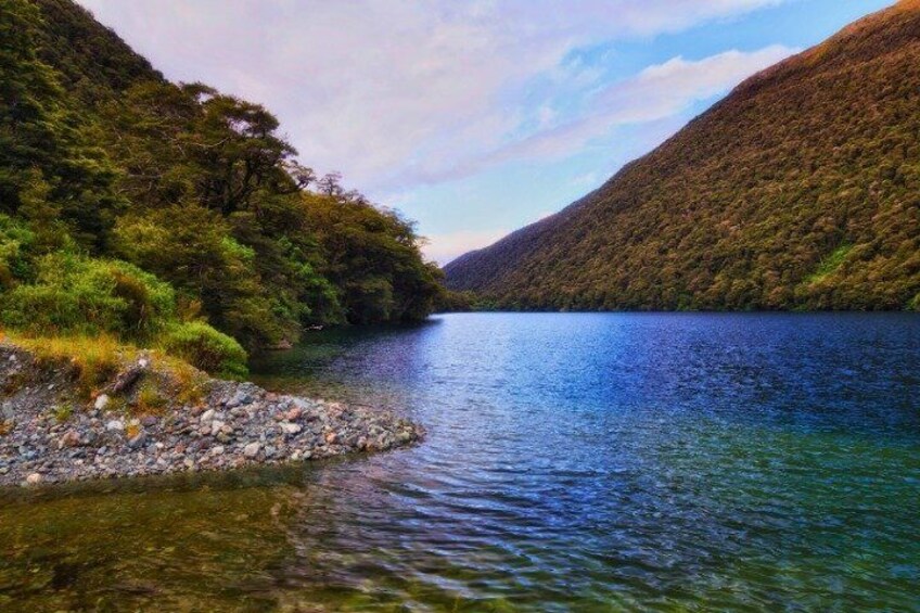 A calm lake surrounded by forested hills. 3