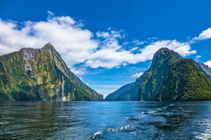 A fjord with steep, forested mountains and calm water. 2