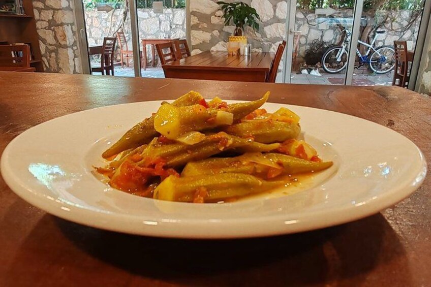 A plate of stuffed zucchini with tomato sauce on a wooden table. 4