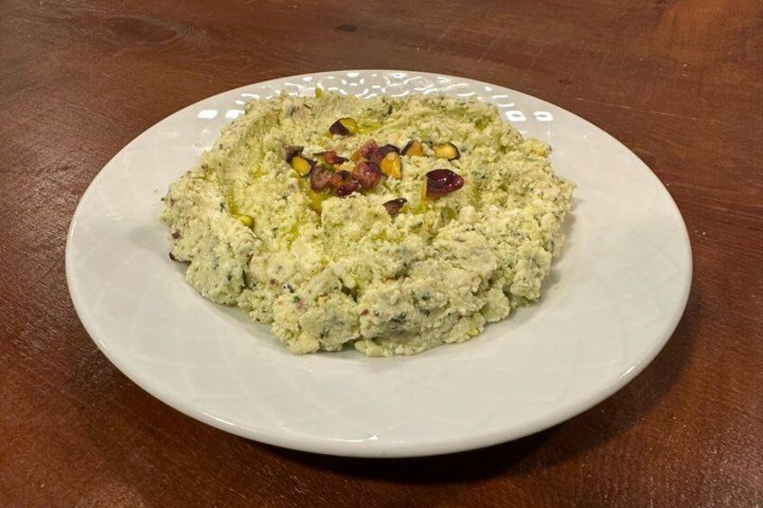 A plate of food with a creamy texture, garnished with nuts and dried fruits. 5