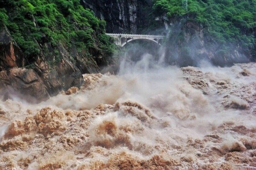 A turbulent river with a bridge in the background. 3