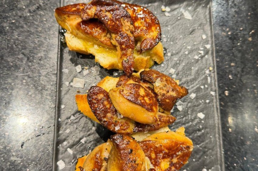 A grilled sandwich with melted cheese and a crispy exterior, placed on a metal surface with salt crystals. 3