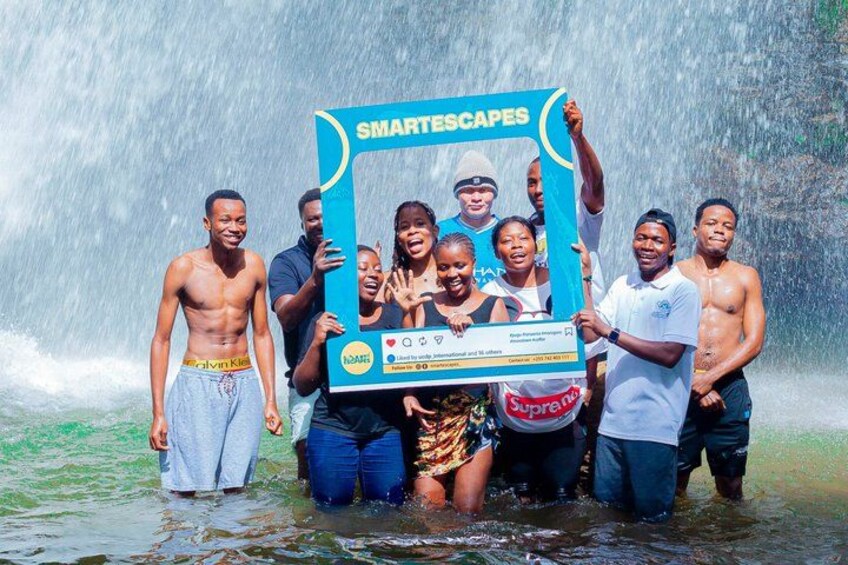 A group of people standing in water with a large blue frame in the foreground. 4