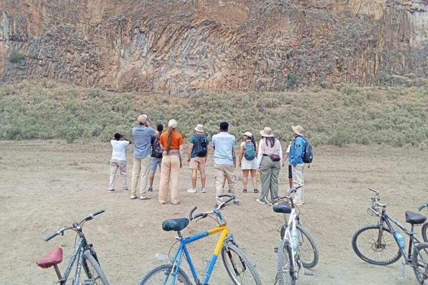 A group of people standing in a desert landscape with bicycles. 3