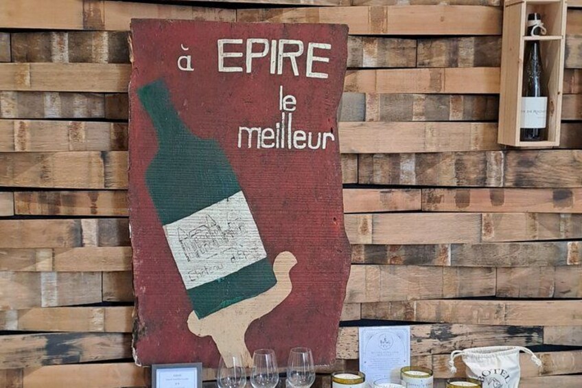 A wooden wall with a large sign featuring a wine bottle and text. 4