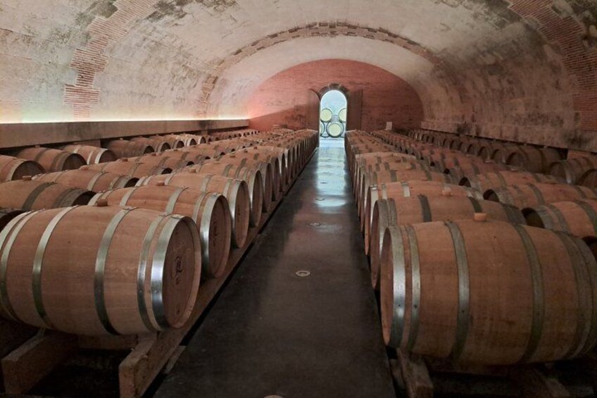 A wine cellar with rows of wooden barrels. 2