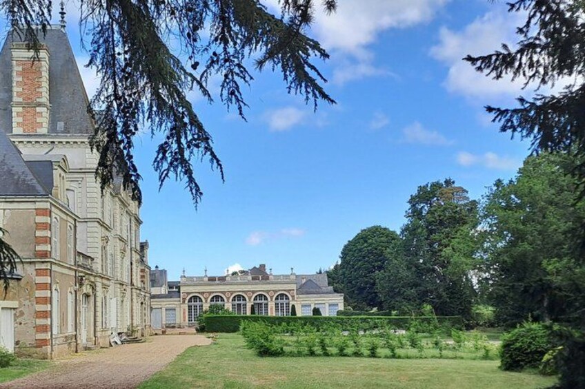 A historic building with a large garden and a clear blue sky. 5
