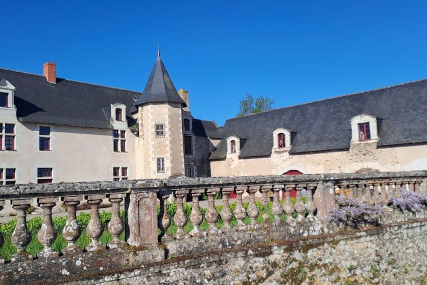 A historic building with a tower, a stone balustrade, and a clear blue sky. 1