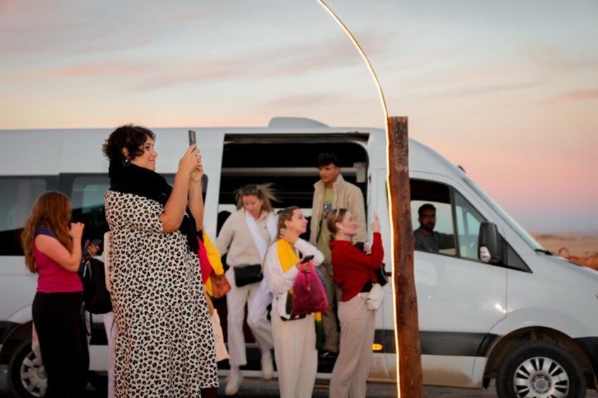 A group of people boarding a white van. 2